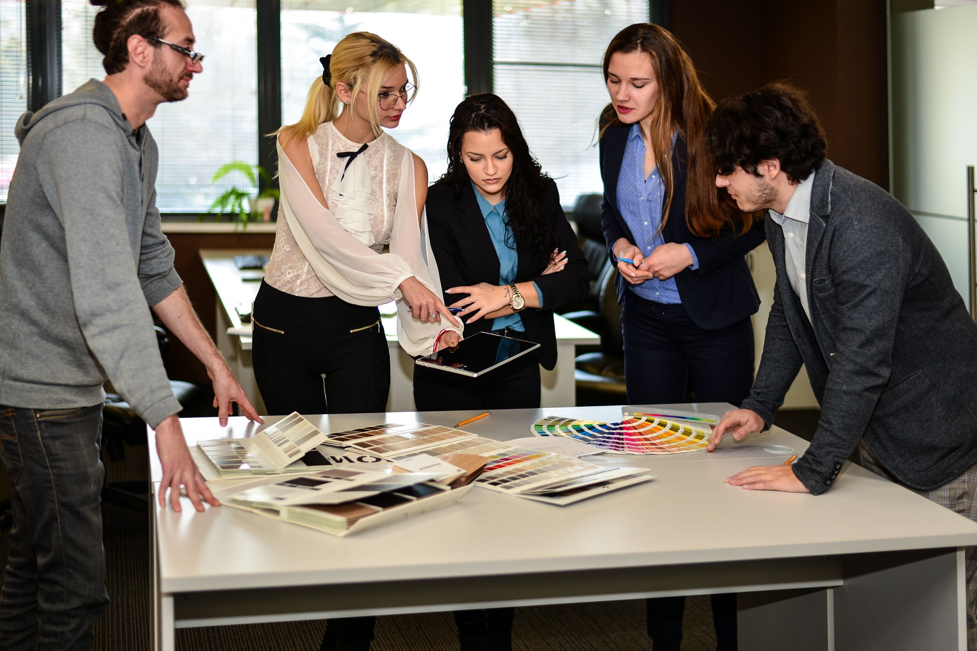 A team of designers discuss the main color of the new advertising campaign.