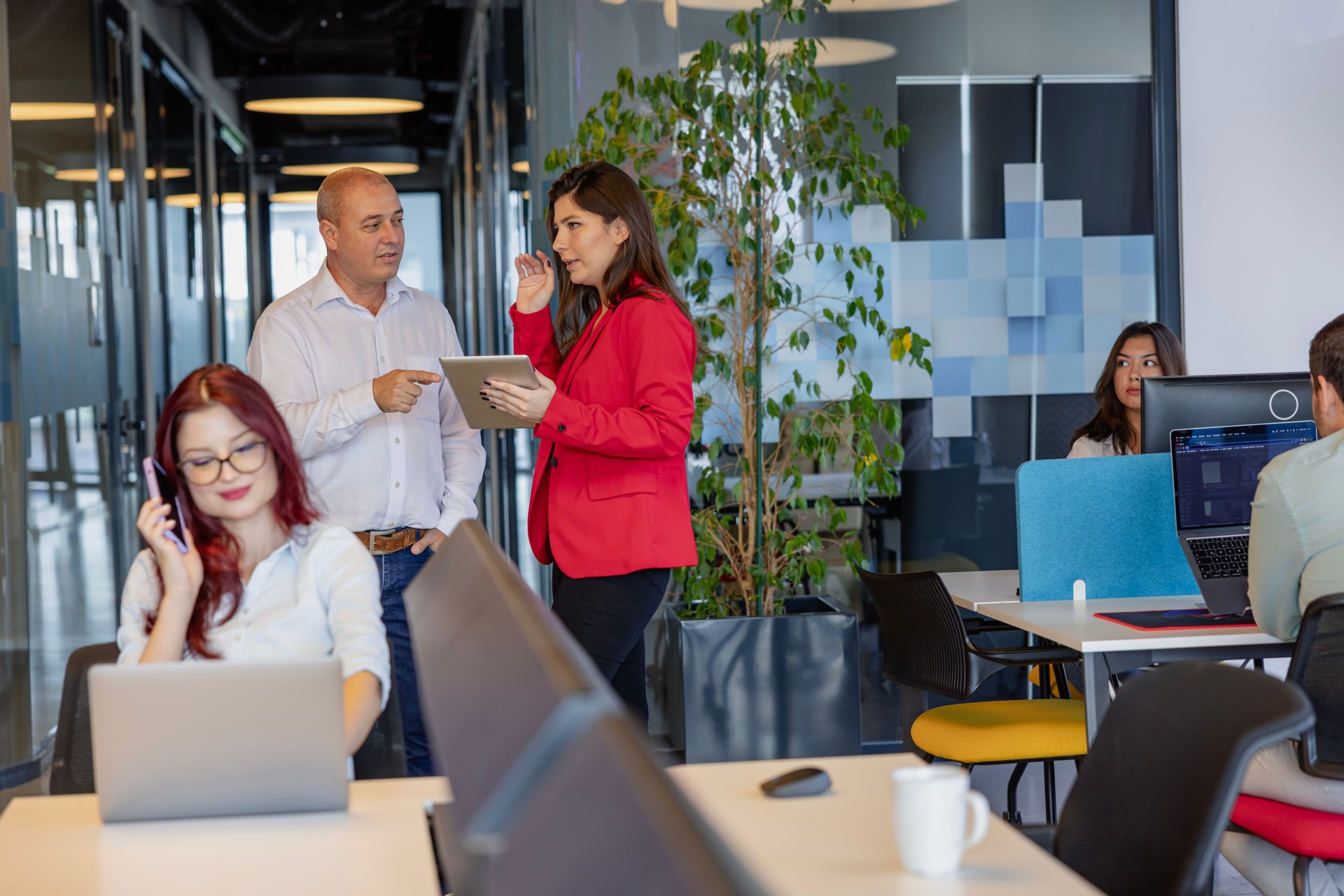 Business Colleagues Utilizing Digital Tablet for Work in a Modern Office Building